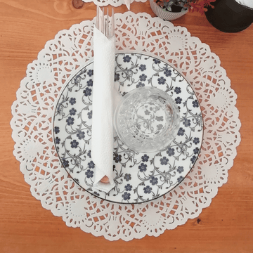 Tovagliette di pizzo sotto piatti e posate